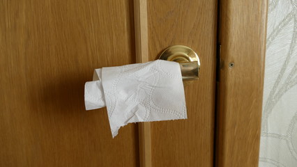 door handle wrapped with toilet paper to protect against coronavirus pandemic