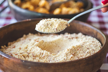 Brazilian crumbs (farofa) with Crackling (torresmo) at background