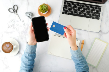 woman shopping online on the mobile phone application with the blue credit card. flat lay and modern style.