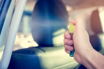 Hand spraying alcohol,disinfectant on  car handle (hand holder) in her car,prevent infection of Covid19,Coronavirus,nCoV,contamination of germ,bacteria,wipe clean surfaces are frequently touch