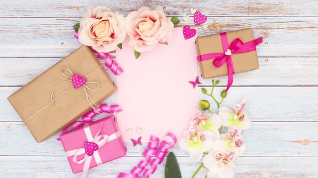 Flowers and gifts appear around pink paper - Stop motion 