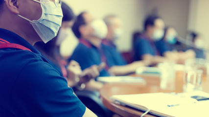 Blurry image of Business people wear masks to prevent Coronavirus (Covid-19) in meeting room. Startup business team brainstorming on meeting workshop.