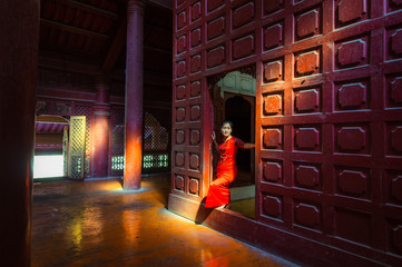Burmese woman in traditional dress standing the door 