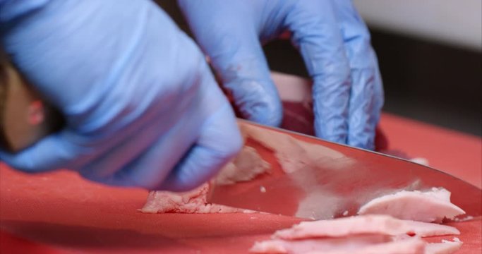 Meat packer preparing steak - close up as man slices fat off