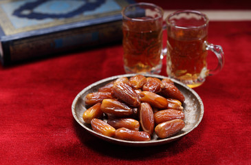 Dates fruit and Islamic Book Koran on carpet background, Islamic background in mosque