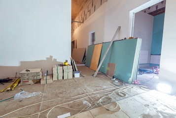 Working process of installing plasterboard or drywall for making gypsum walls in apartment is under...
