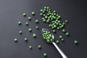 Healthy fresh green peas top view flat lay with black background.