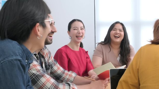4k uhd slow motion of Group of asian and caucasian young creative happy enjoy laugh smile and great success emotion teamwork people business startup entrepreneur casual brainstorm business meeting 
