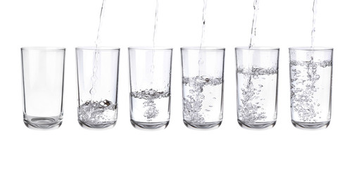 Pouring water into a separate glass on a white background. Clean drinking water concept