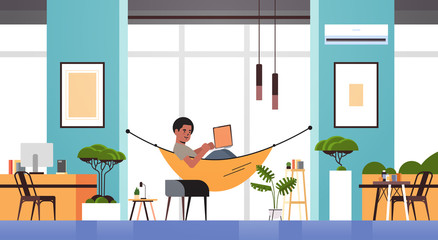 african american man freelancer using laptop working at home during coronavirus quarantine self-isolation freelance concept modern living room interior horizontal full length vector illustration