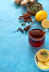 Ginger tea with lemon in glass cup at blue background. Space for a text.