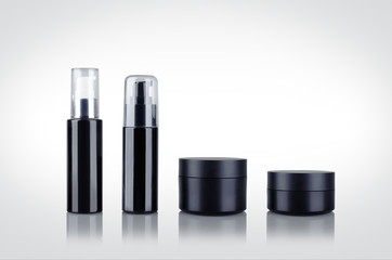 Obraz premium Set of black shiny cosmetic dispenser bottles and cartridges