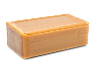 A piece of brown soap, isolate on a white background, close-up. Mockup, a place for your label. Soap as a means of hygiene and a way to protect against germs. Tar antibacterial baby soap