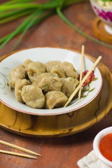 Delish food, meat ball  served with chili sauce on ceramic plate.
