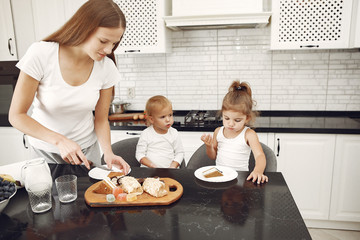 Mother with children. Family have breakfas. Kids in a kitchen