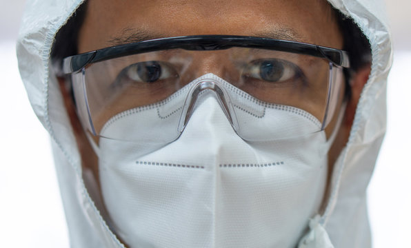 close up picture of asian doctor wearing personal protective equipment or ppe to treat patient with covid-19 or coronavirus infection in hospital