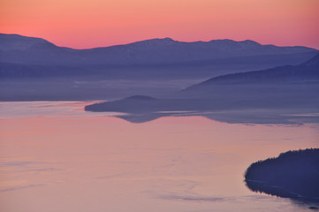 夜明けの湖、山並みのシルエット。屈斜路湖、北海道、日本。