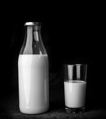 bottle and glass of milk on a black background