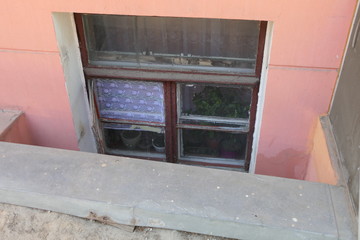 An old window, with dark frogs, in one of which is guipure fabric: anti-mosquito and for good air movement.