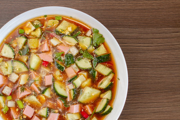 Traditional Russian summer cold soup okroshka with kvass on plate. Top view. Free copy space