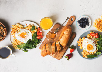 Fried egg, spinach, waffles and cup of coffee espresso, bread, baguette, muesli on white background