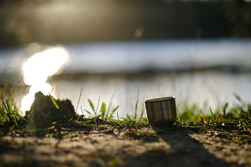 Thermal mug cup isolated with steam in nature setting with beautiful warm sunlight