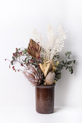 Stylish modern dried flower arrangement in a clay vase. Eucalyptus leaves, king protea, kangaroo paw, banksia ,gold palm leaf  and ruscus leaves. Beautiful gifts for Anniversary, Birthday, Mothers day