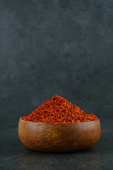 Red chili pepper flakes shot from above on dark background stock photo