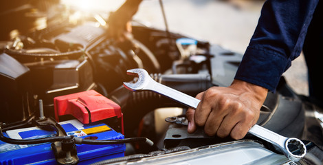 Auto mechanic hands using wrench to repair a car engine. concepts of car insurance support and services.