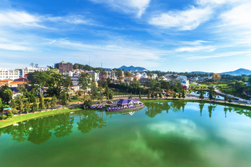 Obraz premium Top view aerial photo from flying drone of a Da Lat City with development buildings, transportation. Tourist city in developed Vietnam. Xuan Huong lake 