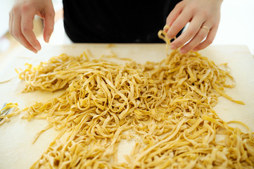 Staying at home with your family and preparing fresh home-made pasta (tagliatelle): mom moving...