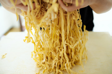 Staying at home with your family and preparing fresh home-made pasta (tagliatelle): mom moving...