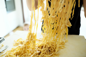 Staying at home with your family and preparing fresh home-made pasta (tagliatelle): mom moving...