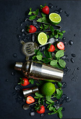 Fresh ingredients and props for making summer cold cocktail strawberry mojito. Top view with copy space.