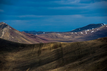 Obraz premium clouds float across the sky, forming a light-shadow pattern on the mountains