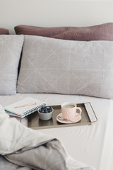 Studying or working in the morning from bed: coffee and blueberries served on a metal tray with a note book and pen. Breakfast in bed