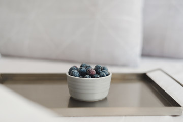 Small bowl of fresh blueberries served on a metal tray. Healthy dessert for breakfast in the bed