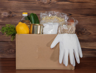 Coronavirus food donation. Food in a box with gloves, close-up. Food delivery.