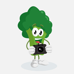 Obraz premium Brocoli Logo mascot with camera pose and background with flat design style for your mascot branding.