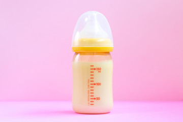 ピンクの背景と哺乳瓶とおもちゃ