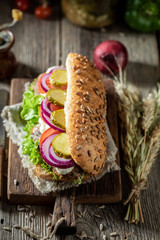 Tasty sandwich with roasted pork neck, gherkins and red onion