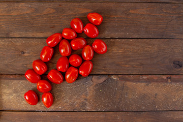 Fototapeta na wymiar Fresh cherry tomatoes on a wooden table. Top view, free space for text