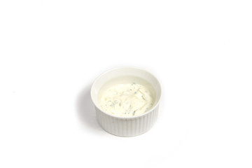 Garlic sauce with green leaves in round ceramic plate isolated of white