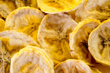 Dried banana chips, sliced in thin circles. Background for healthy and natural nutrition.