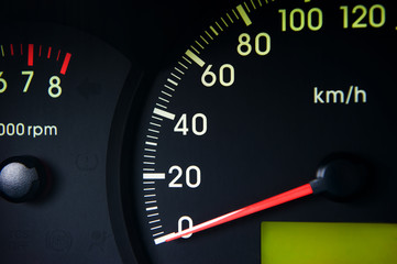 Close-Up of a Glowing black car Speedometer with a red arrow indicating 0