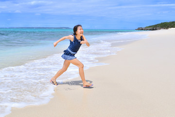 Fototapeta na wymiar ビーチで走る女の子(沖縄　宮古島　長間浜)