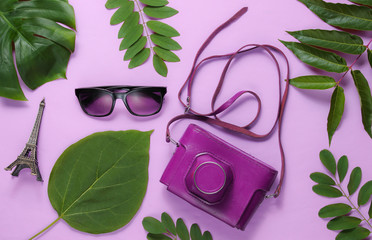 Jorney to Paris. Women's accessories, retro camera, figurine of the Eiffel tower on pink pastel...