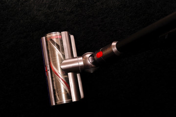 aspirateur sans fil sur un tapis noir © Guiolo