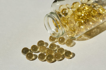 Capsules with medication are poured out of a jar or bottle, gelatin tablets with oil, vitamin or collagen. A medicinal product or natural cosmetic product.