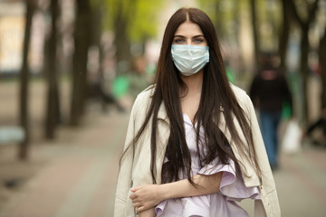 COVID-19 Pandemic Coronavirus Woman on city street wearing face mask protective for spreading of disease virus. Girl with protective mask on face against Coronavirus Disease 2019.